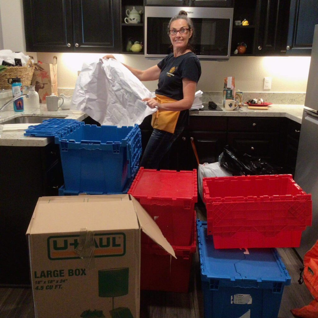 A Professional Move Manager Unpacking the Boxes and Organizing the Kitchen in a New Home for a Client